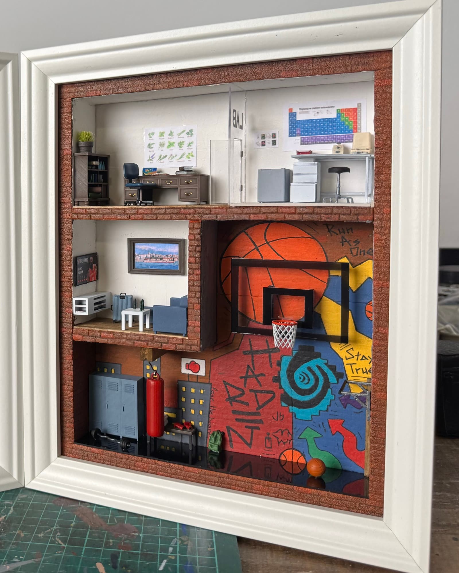 Framed miniature with an office, a living room and a graffiti basketball court