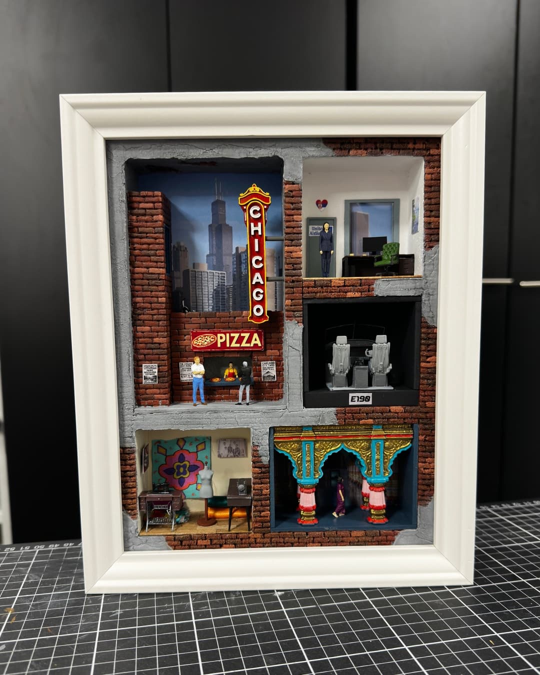 Framed miniature with the Chicago theatre sign, a pizza place and four small rooms