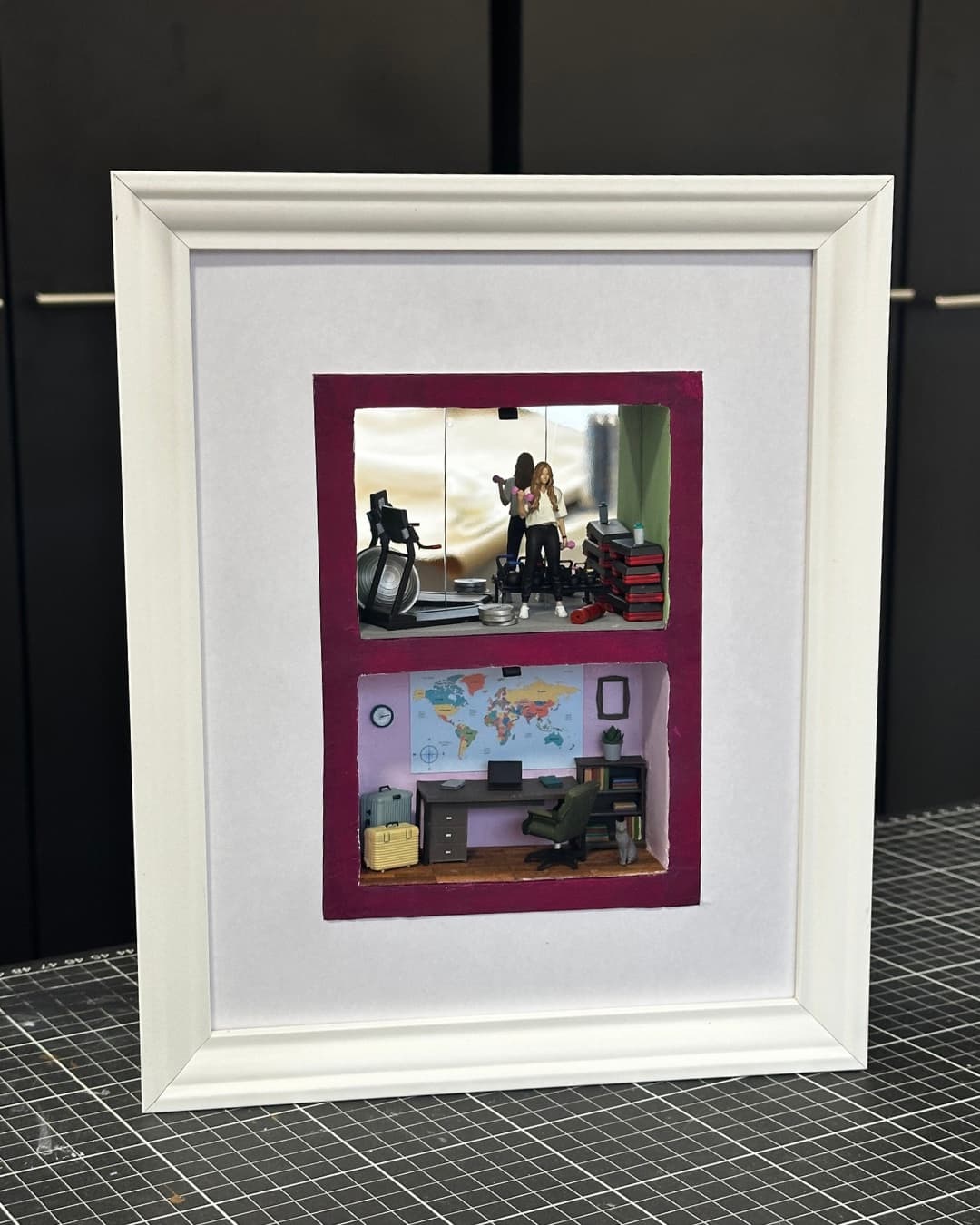 Framed two-level miniature with a couple in a home gym above a home office
