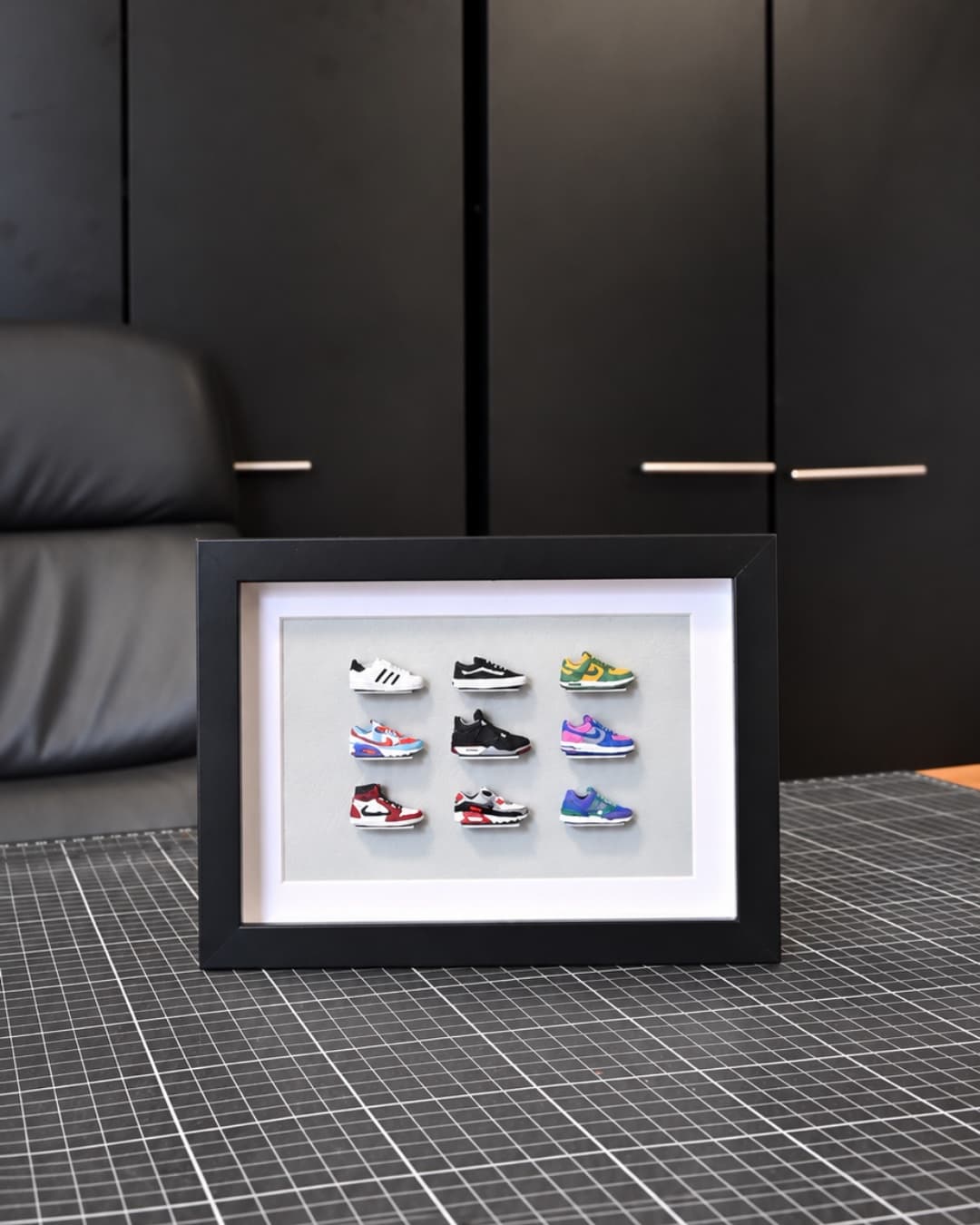 Framed set of nine hand-painted miniature sneakers