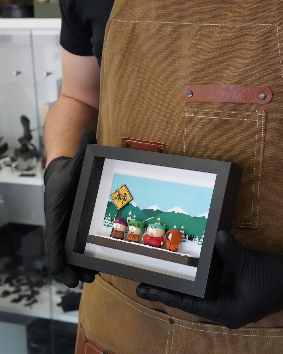 Framed miniature of the South Park bus stop, held by the maker