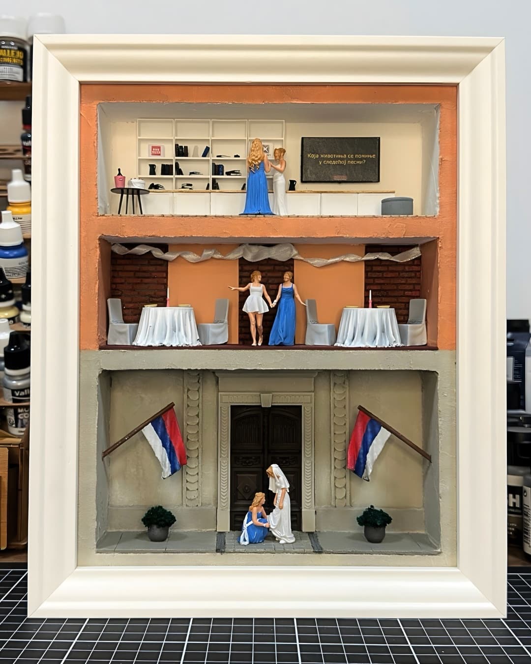 Framed three-level wedding miniature with a bridal boutique, a reception hall and the bride at the entrance